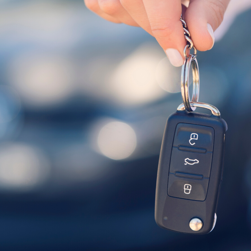 Female car salesperson handing over new car keys